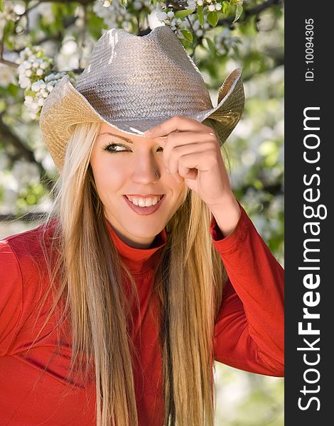 Pretty woman with cowboy hat and blossom trees. Pretty woman with cowboy hat and blossom trees