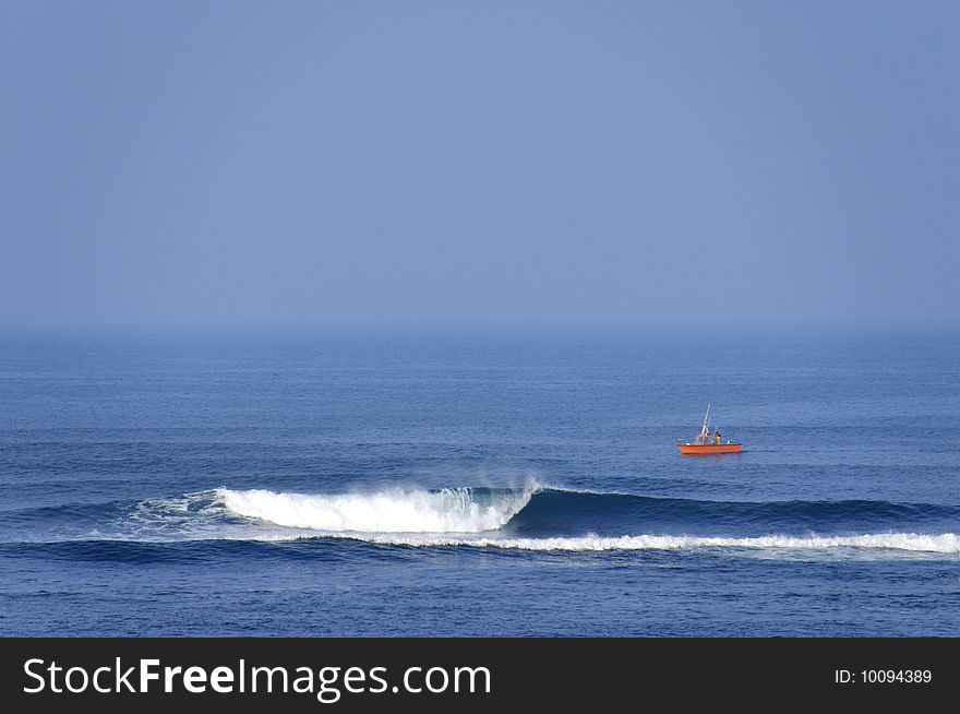 A self fish man on an orange boat. A self fish man on an orange boat