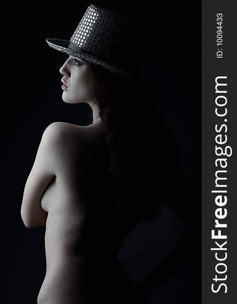 Sexual brunette in a hat on a black background