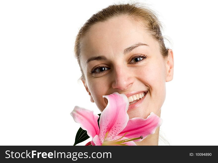 A smiling nice blond girl posing with a pink lily near her face on a white background. A smiling nice blond girl posing with a pink lily near her face on a white background