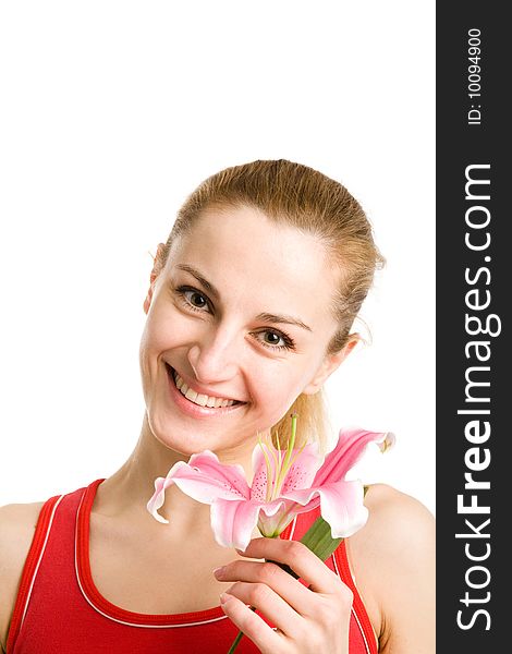 A  smiling nice blond girl in red posing with a pink lily near her  face on a white background. A  smiling nice blond girl in red posing with a pink lily near her  face on a white background