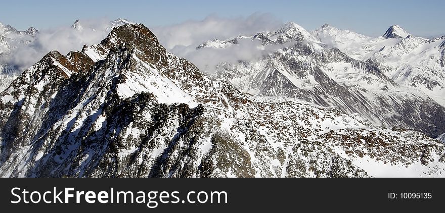 Panorama of Alpian mountain ranges covered with snow over the clouds. Panorama of Alpian mountain ranges covered with snow over the clouds.