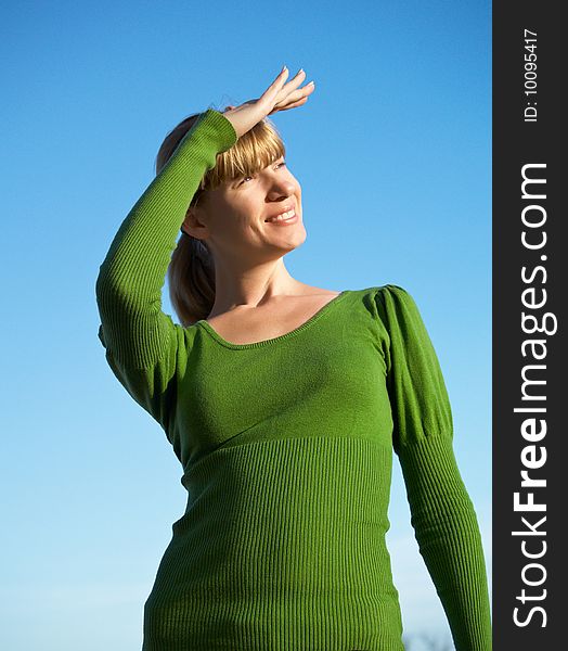 Portrait of the young woman posing on a background of the dark blue sky. Portrait of the young woman posing on a background of the dark blue sky