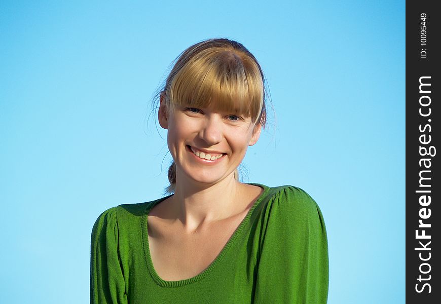 Portrait of the young woman posing on a background of the dark blue sky. Portrait of the young woman posing on a background of the dark blue sky