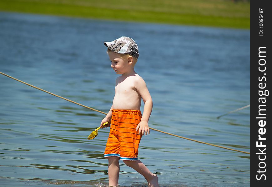 The boy has a rest on the river a sunny day. The boy has a rest on the river a sunny day