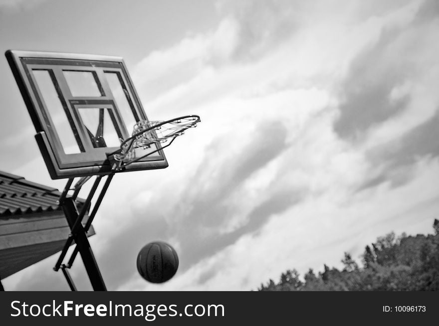Black and white image of basketball entering the hoop
