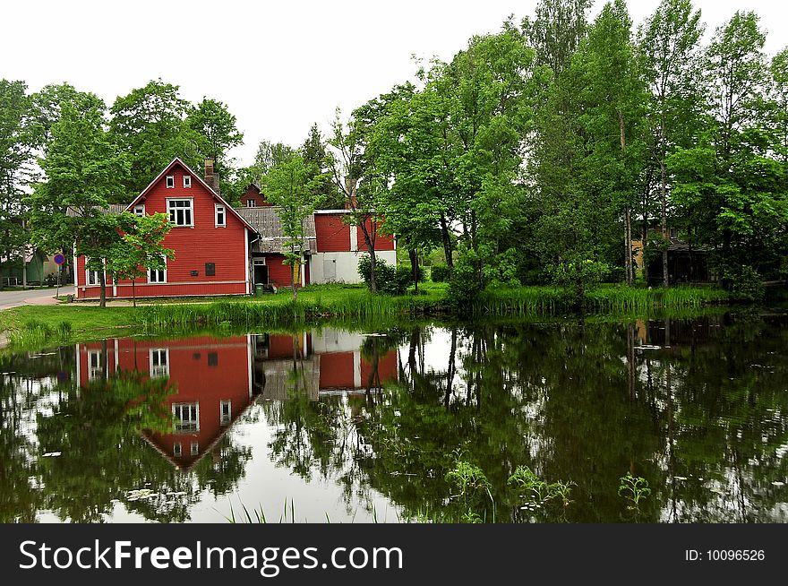 Reflection of the red house in Estonian river