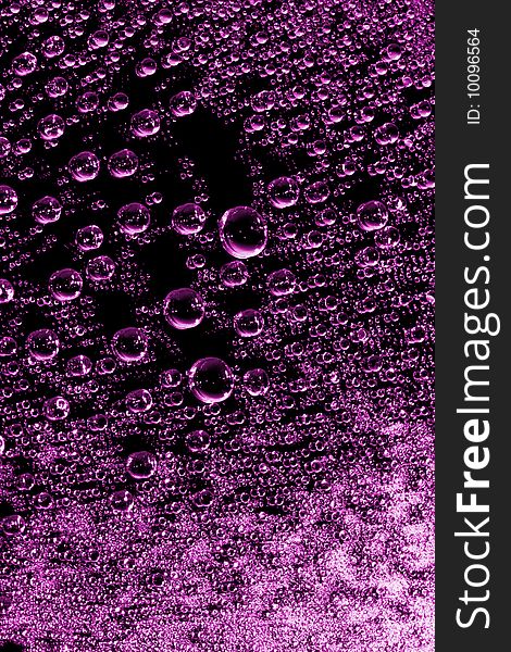 Pink water drops against black background