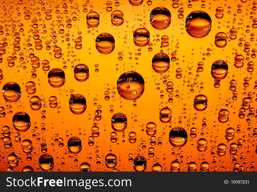 Orange water drops against black background