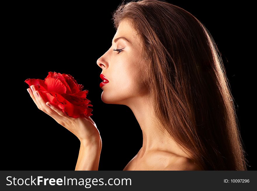 Taken in profile beautiful naked brunette with a rose in hand on a black background. Taken in profile beautiful naked brunette with a rose in hand on a black background
