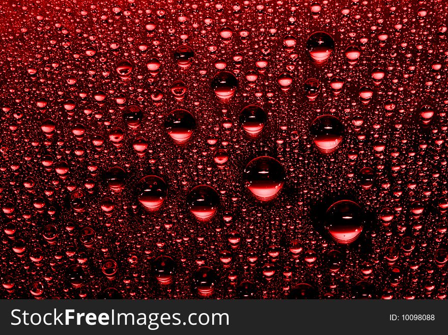 Red water drops against black background