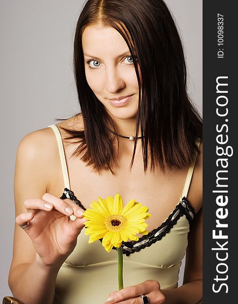 An image of a woman with a yellow flower. An image of a woman with a yellow flower