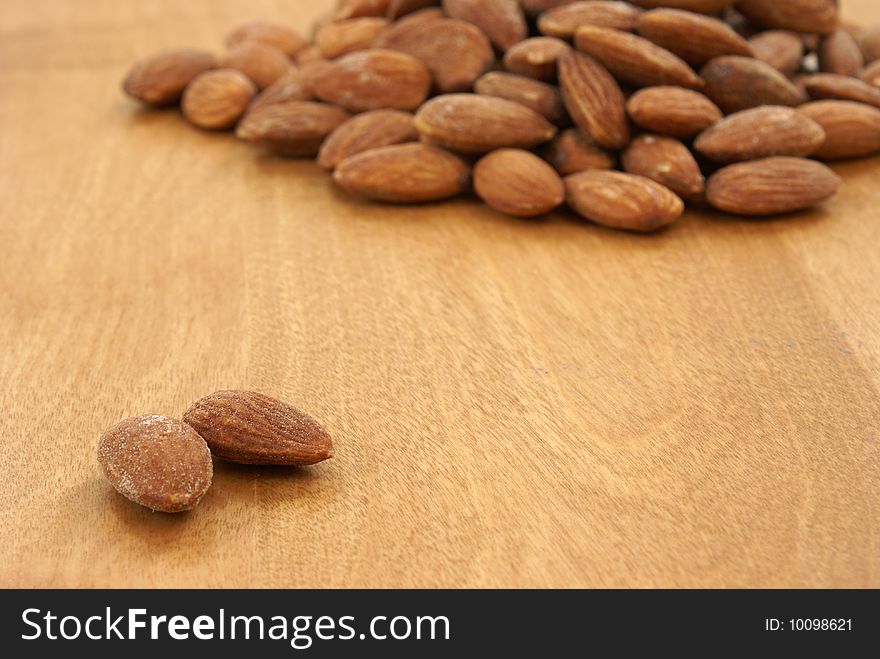 A heaping pile of almonds behind two that are away from the rest.