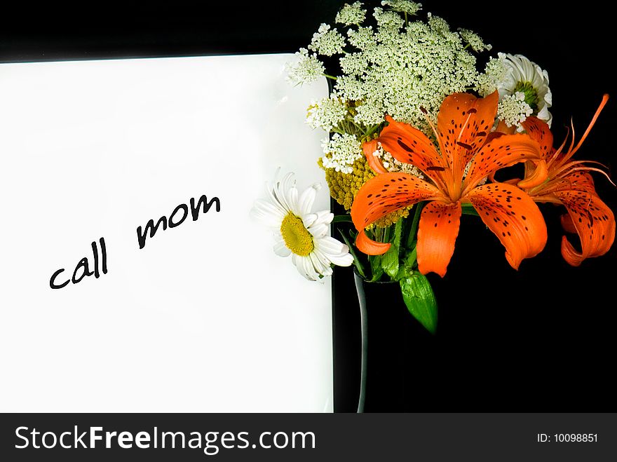 A message on dry erase board with bouquet in black vase. A message on dry erase board with bouquet in black vase.