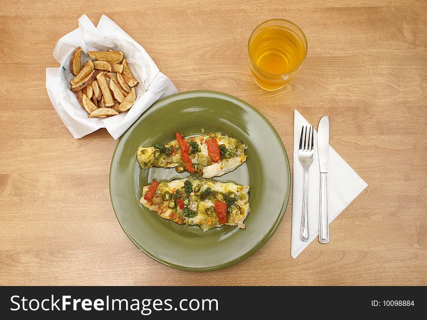 A plate of fresh fish with many seasonings, alongside a bowl of fresh cut frenchfries. A plate of fresh fish with many seasonings, alongside a bowl of fresh cut frenchfries.