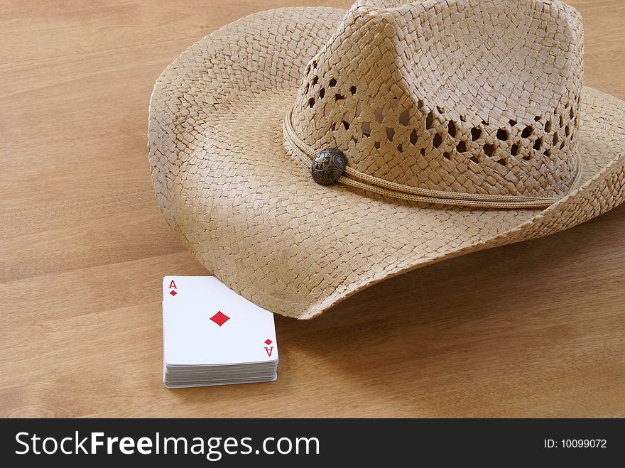 A deck of cards and a hat are holding the table for the comming players. A deck of cards and a hat are holding the table for the comming players.