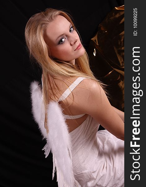 Beautiful blond fashion model posing in studio with angel wings. Beautiful blond fashion model posing in studio with angel wings