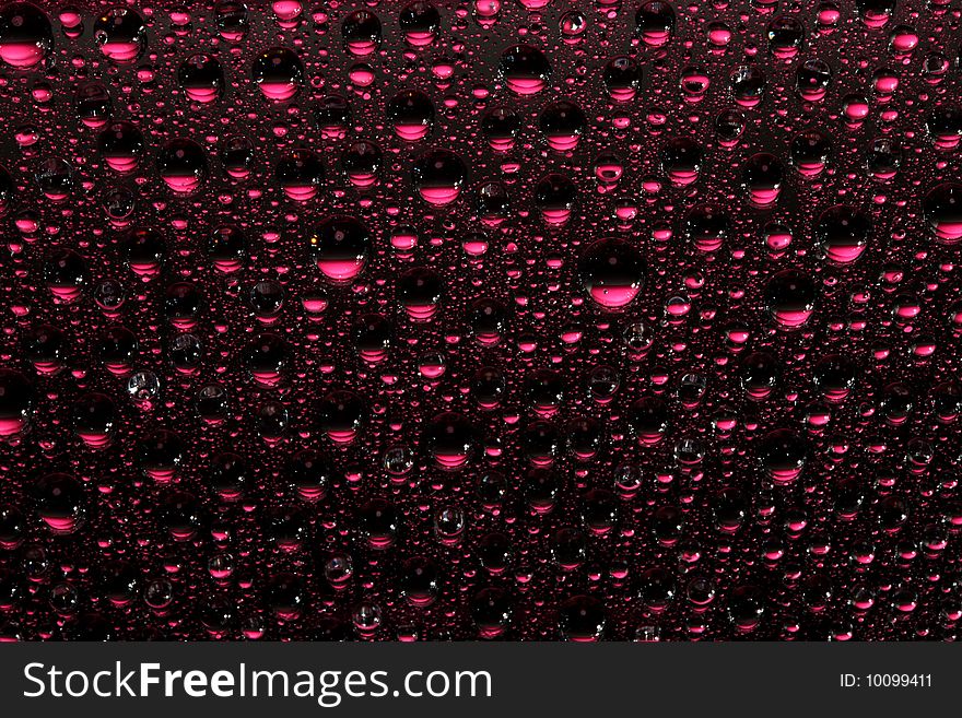 Pink water drops against black background