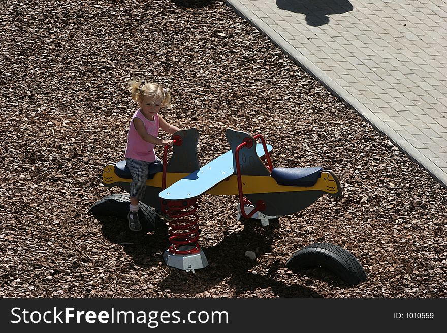 The girl playing on a children's playground. The girl playing on a children's playground