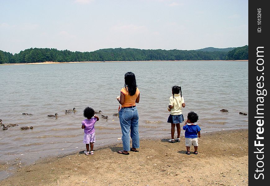 Mother and children feeding ducks at Sweetwater state park Georgia. Mother and children feeding ducks at Sweetwater state park Georgia