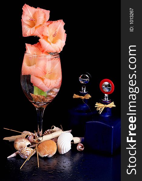 A wine glass with flowers arranged with some artful objects. A wine glass with flowers arranged with some artful objects