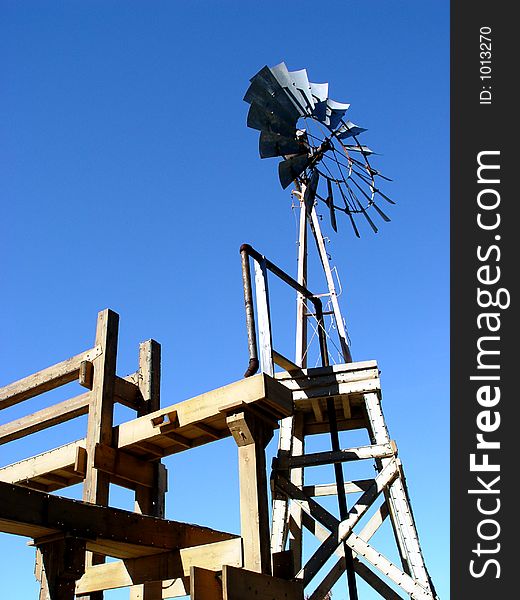 Farm windmill that runs on the energy generated by a wheel of adjustable blades or slats rotated by the wind.