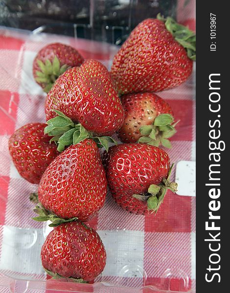 Fresh strawberries in plastic on a picnic table