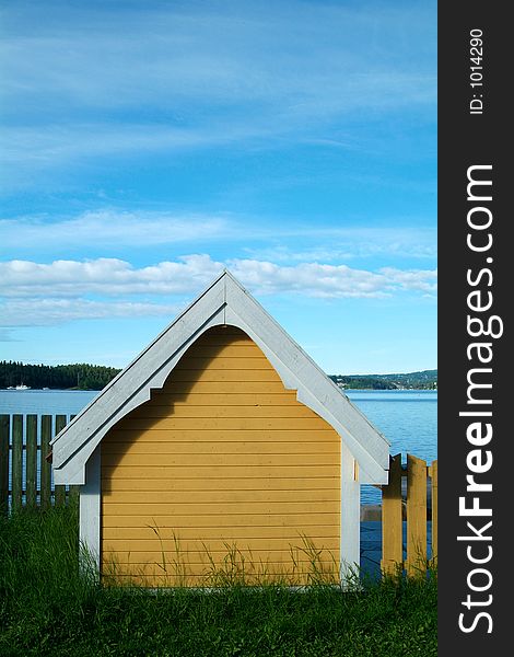 Small, yellow, wooden boathouse by the sea. Small, yellow, wooden boathouse by the sea