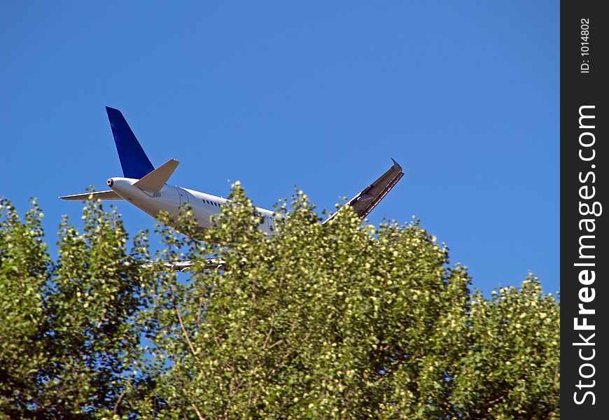 Aeroplane landing behind the trees. Aeroplane landing behind the trees