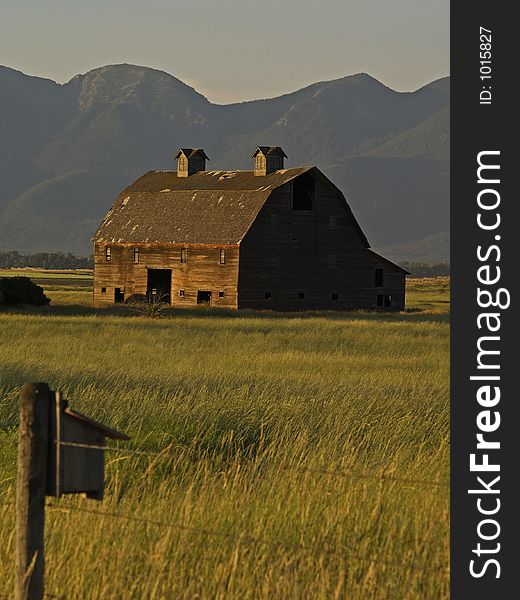 This image of the old barn with the field of grain and the mountains in the background was taken in western MT. This image of the old barn with the field of grain and the mountains in the background was taken in western MT.