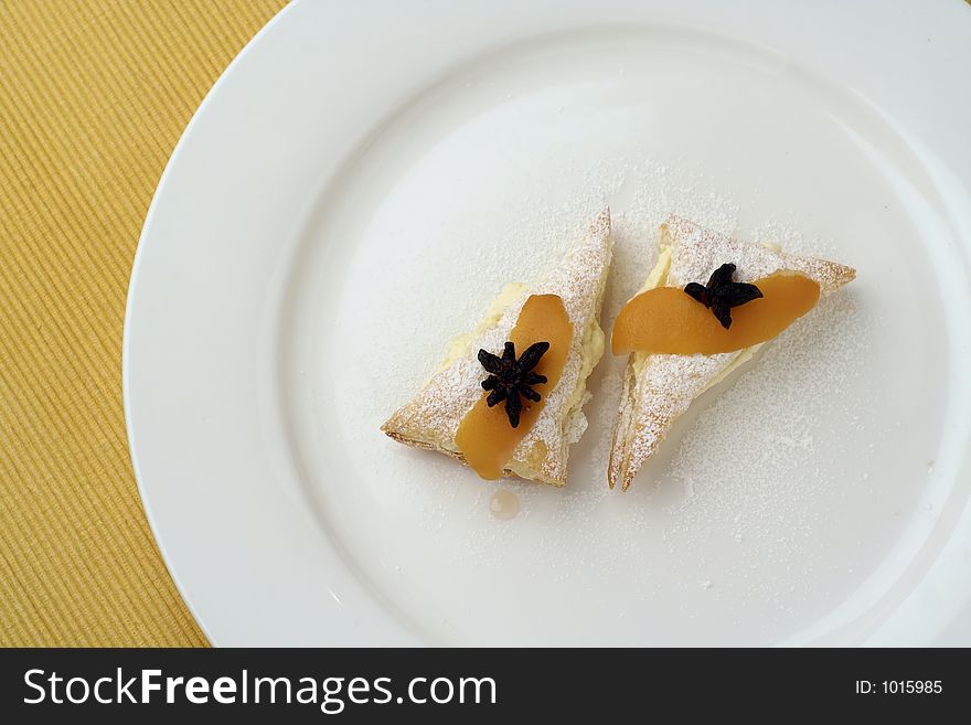 Candied lemon peel dessert, with puff pastry and lemon vanilla whipped cream topped with star anise. Candied lemon peel dessert, with puff pastry and lemon vanilla whipped cream topped with star anise.