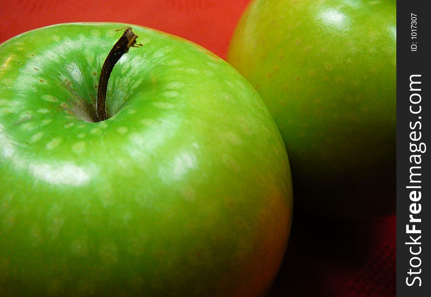 Big Granny Smith apple on a red  background.