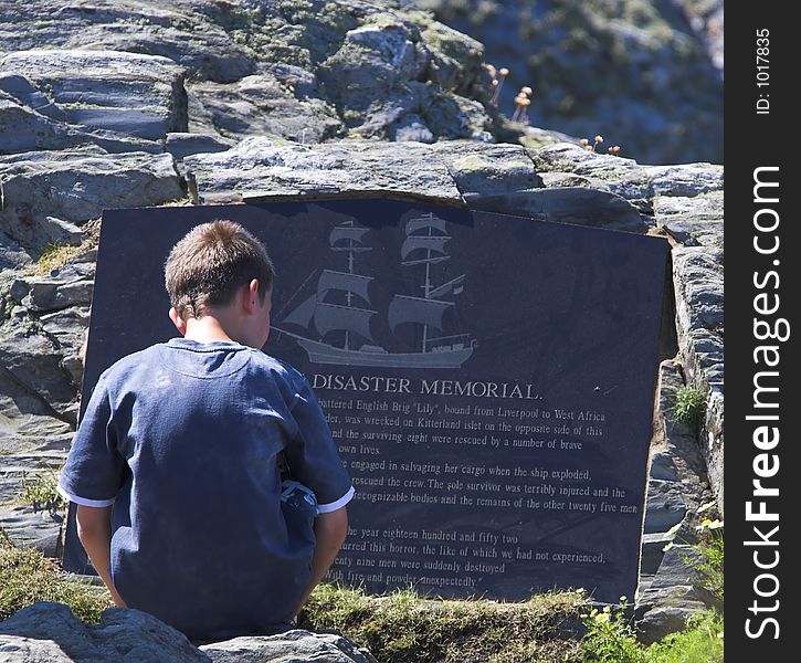Young child reading memorial stone