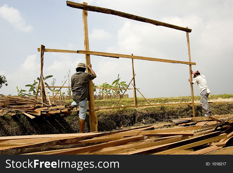 Men building temporary shelter on a rice paddy in rural Philippines. Men building temporary shelter on a rice paddy in rural Philippines