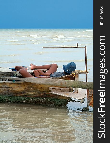 Man taking a nap in his traditional, wooden boat. Man taking a nap in his traditional, wooden boat