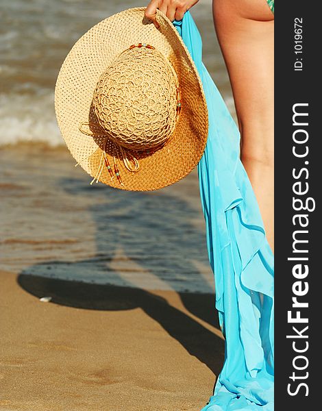 Detail of a hat and a scarf hold by a beautiful women, marvelous sunny beach. Detail of a hat and a scarf hold by a beautiful women, marvelous sunny beach.