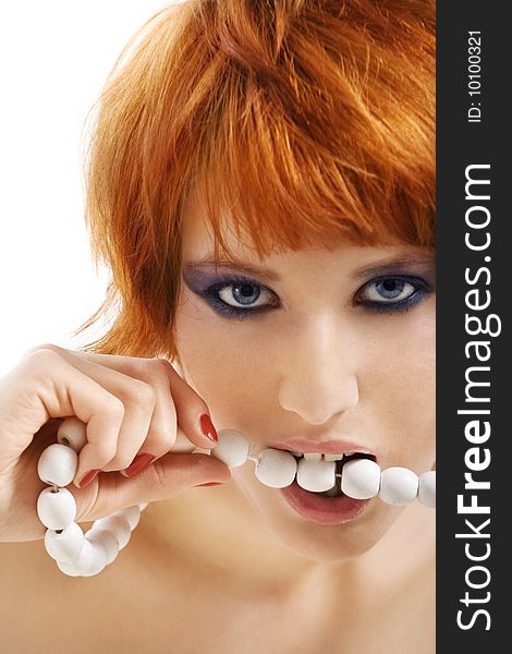 Red haired girl holding beads in mouth