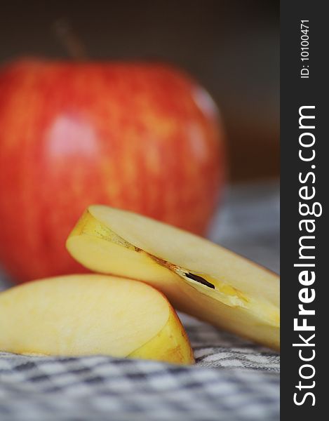 Sliced apple in front of apple on checked dishtowel
