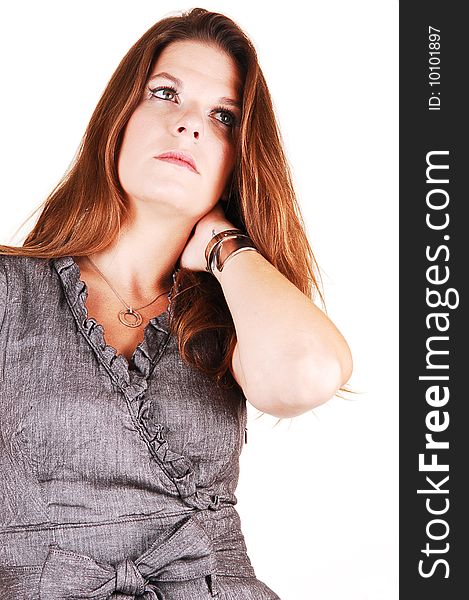 Young light red haired woman in an gray dress standing in the studio 
for white background, has her left hand on the neck under the hair. Young light red haired woman in an gray dress standing in the studio 
for white background, has her left hand on the neck under the hair.