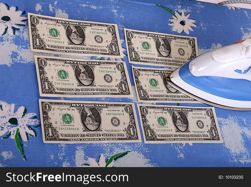 Woman ironing dollars on a board