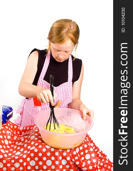 Redhead girl is making pancake dough isolated on white