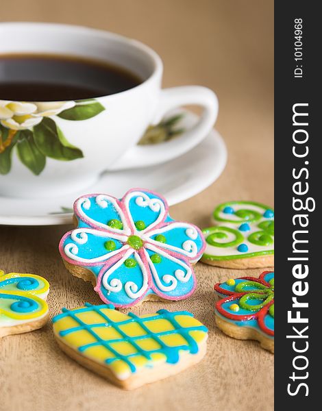 Richly decorated cookies on a table with a coffee cup