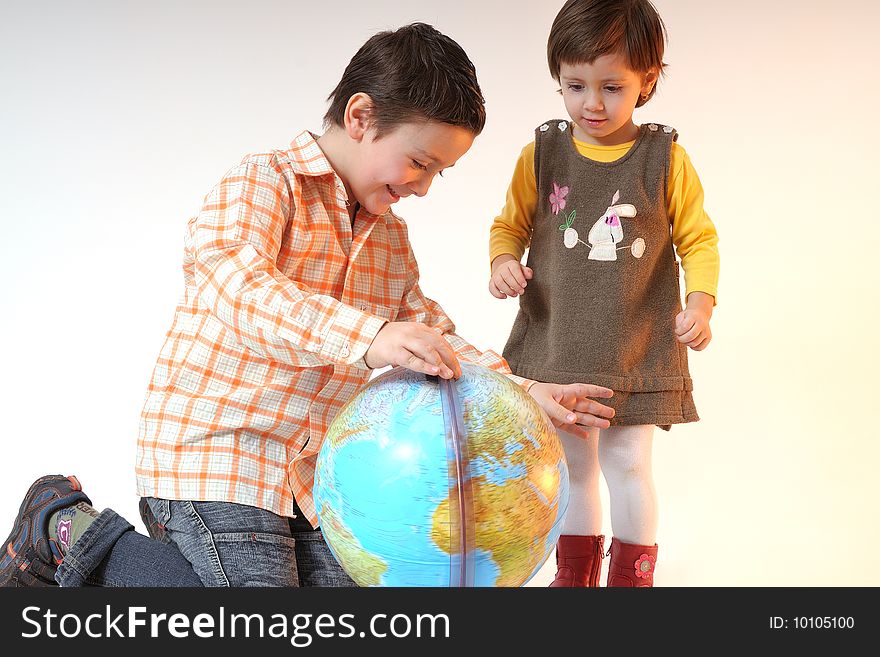 Boy and girl playing with globe in office. Boy and girl playing with globe in office