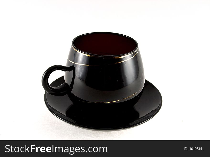Blackenning cup with saucer on white background