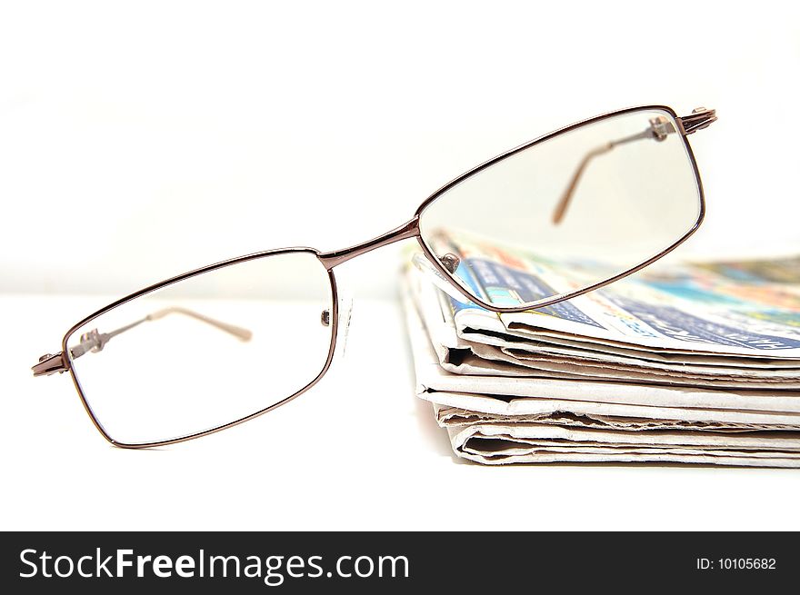 Few fresh newspaper with the pair of glass on  table