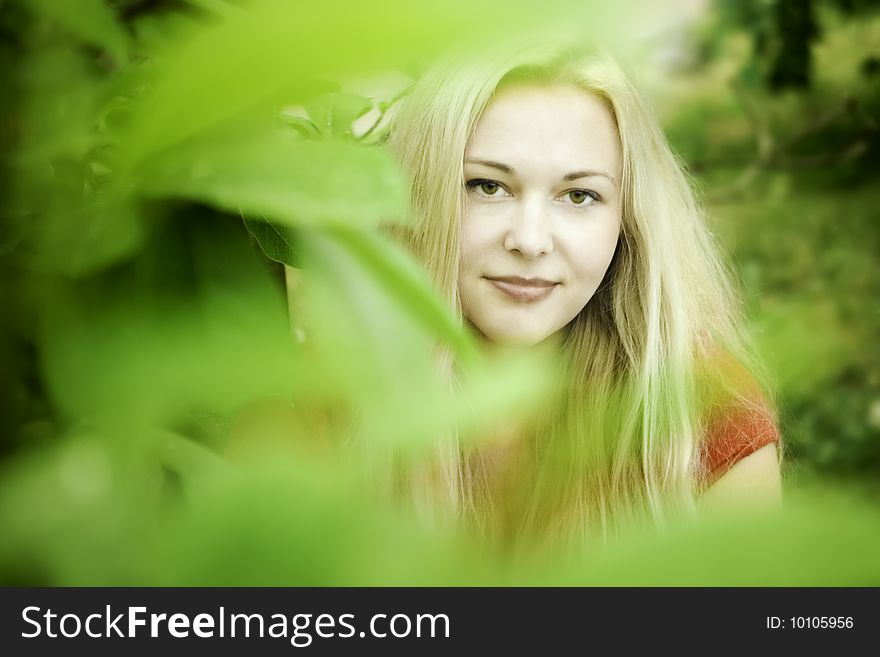 Smiling young blonde beauty in park
