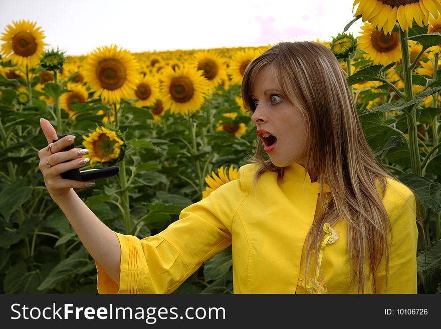 Wondering woman with mirror in sunflowers