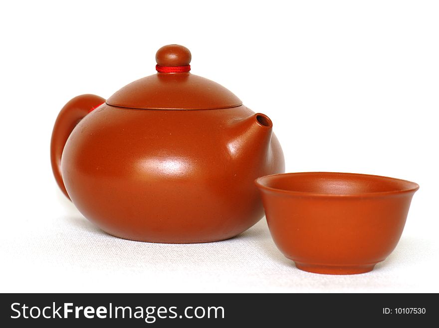 Chinese teapot and teacup against white background