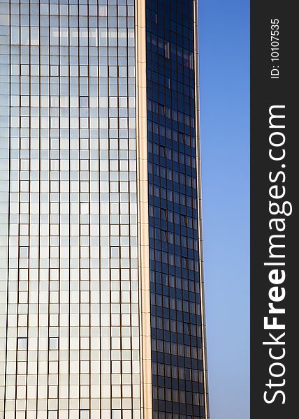 Blue skyscraper facade over clear sky.