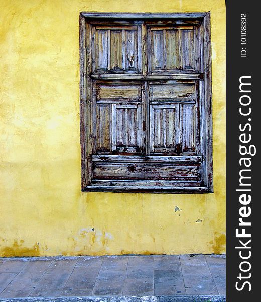 Old wooden window in the yellow wall. Old wooden window in the yellow wall